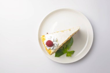 Ahududulu kek. Beyaz arkaplanda servis edilen vanilyalı meyveli kekten bir dilim. Çay ya da kahve zamanı. Boşluk afişini kopyala.