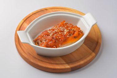 Fırınlanmış sebze güveci ve balık. Beyaz arka planda beyaz bir tencerede hizmet vermiş. Lezzetli mevsimlik akşam yemeği, sonbahar yemeği.