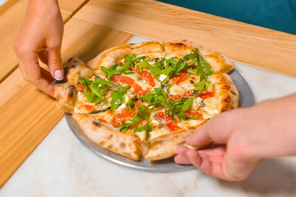 Image of friends hands taking slices of pizza. Top view, flat lay. Italian cuisine concept, eating delicious pizza in a restaurant. Eating out concept.