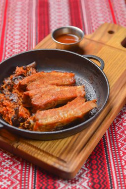 Lezzetli bir akşam yemeği ve temiz yeme konsepti. Tavada kızarmış et, arka planda düzlük. Geleneksel Ukrayna masa örtüsü, Ukrayna konsepti.