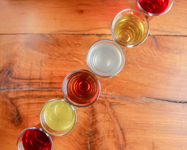 在小玻璃杯中夹入酒精 天然水果酒精饮料 镜头放在木制桌子上 背景模糊 覆盆子 草莓及其他浆果色泽 有机酒精提取物 — 图库照片
