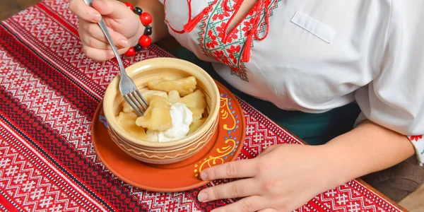 Pierogi or pyrohy, varenyky, traditional dumplings served with sour cream in bowl on wooden table. — Stock Photo, Image