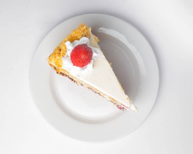 Beyaz izole edilmiş arka planda kremalı vanilyalı ve çikolatalı kek. Beyaz tabakta servis edilmiş. Çay ya da kahve için lezzetli bir tatlı..