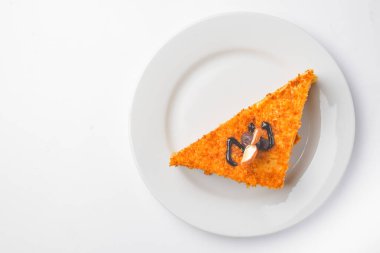 Beyaz izole edilmiş arka planda kremalı bir parça vanilyalı ve ballı kek. Beyaz tabakta servis edilmiş. Çay ya da kahve için lezzetli bir tatlı..