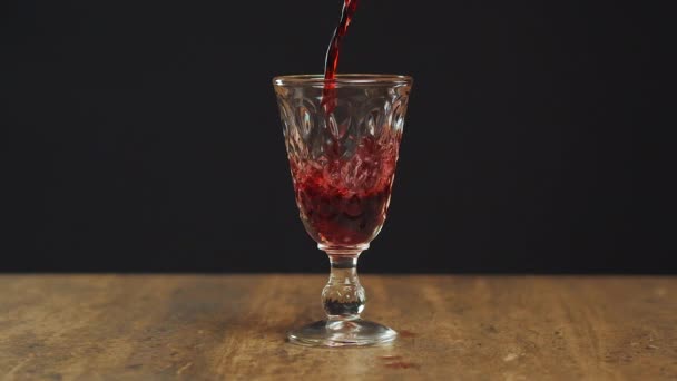 在特慢镜头下 用红酒加满酒杯的特写镜头 把红酒倒进杯子里 红酒在玻璃杯中形成美丽的波浪 — 图库视频影像