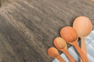 Köy ahşap bir masada peçeteli tahta kaşıklar. Düz konum, üst görünüm, uzay afişini kopyala. Ahşap çatal bıçak takımı..