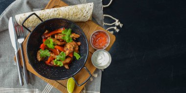 Lavaş ekmeği ve farklı soslarla servis edilen sebzeler ve tavada et. Akşam yemeğinde nefis yemekler, geleneksel yemekler. Bir rustice ahşap masanın üzerinde. Boşluk afişini kopyala.