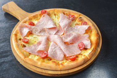Pastırmalı, salamlı ve sebzeli pizza. Erimiş peynirli jambon ve domatesli pizza. Yakın çekim, geleneksel İtalyan mutfağı konsepti..