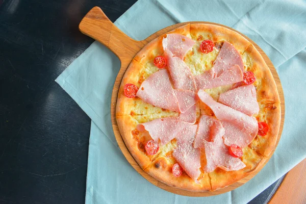 Pastırmalı, salamlı ve sebzeli pizza. Erimiş peynirli jambon ve domatesli pizza. Yakın çekim, geleneksel İtalyan mutfağı konsepti..