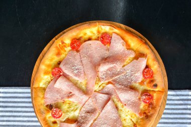 Pastırmalı, salamlı ve sebzeli pizza. Erimiş peynirli jambon ve domatesli pizza. Yakın çekim, geleneksel İtalyan mutfağı konsepti..