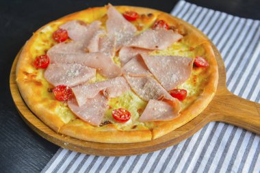 Pastırmalı, salamlı ve sebzeli pizza. Erimiş peynirli jambon ve domatesli pizza. Yakın çekim, geleneksel İtalyan mutfağı konsepti..