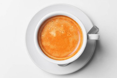 Kahveli espresso beyaz üzerine izole edilmiş. Beyaz bardakta kaşıkla servis edilmiş. Kahve zamanı, yakın çekim fotoğrafı..