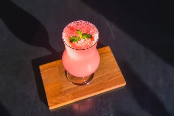 Κοκτέιλ Ροζ Φρούτων Ψηλό Ποτήρι Τουλίπας Σερβιρισμένο Μαύρο Ξύλινο Τραπέζι — Φωτογραφία Αρχείου