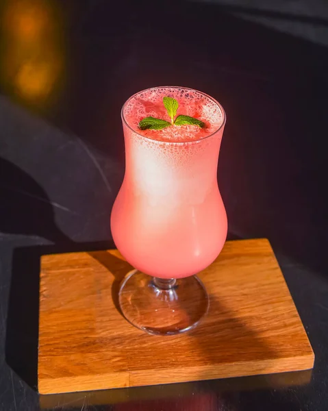 Κοκτέιλ Ροζ Φρούτων Ψηλό Ποτήρι Τουλίπας Σερβιρισμένο Μαύρο Ξύλινο Τραπέζι — Φωτογραφία Αρχείου