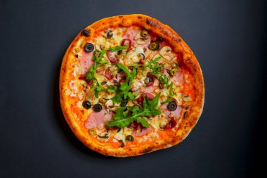 Sıcak, lezzetli, siyah arka planda ev yapımı Amerikan pizzası. Düz yerde, üst tarafta. Geleneksel İtalyan mutfağı kavramı. Salamlı pizza, mantar, zeytin..