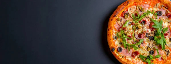 Sıcak, lezzetli, siyah arka planda ev yapımı Amerikan pizzası. Düz yerde, üst tarafta. Geleneksel İtalyan mutfağı kavramı. Salamlı pizza, mantar, zeytin. Boşluk afişini kopyala.