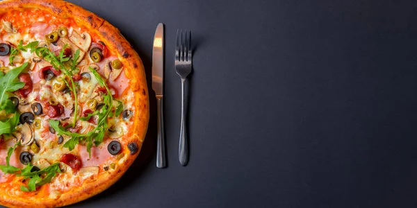 Sıcak, lezzetli, siyah arka planda ev yapımı Amerikan pizzası. Düz yerde, üst tarafta. Geleneksel İtalyan mutfağı kavramı. Salamlı pizza, mantar, zeytin. Boşluk afişini kopyala.