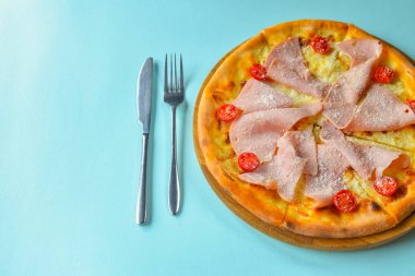 Pastırmalı, salamlı ve sebzeli pizza. Erimiş peynirli jambon ve domatesli pizza. Yakın çekim, geleneksel İtalyan mutfağı konsepti. Pastel mavi arkaplan üzerinde.