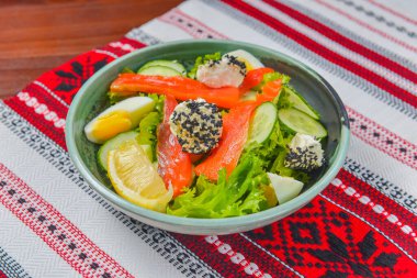 Haşlanmış yumurtalı füme somon salatası, salatalık, susam tohumlu krem peynir ve bir dilim limon. Akşam yemeğinde lezzetli balık salatası..