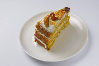 Karamelli ve fındıklı balkabağı katlı kekin yakın çekimi. Mevsimlik karamel şuruplu sonbahar pastası çay için tatlı tatlı ya da beyaz arka planda kahve zamanı..