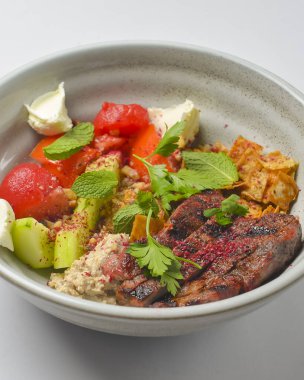 Lezzetli biftek dilimi ve kesilmiş sebze ve peynir ile servis edilen bir kasede. Lezzetli Gürcü yemeği, geleneksel mutfak konsepti..