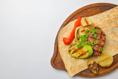 Beyaz arka planda servis edilen lahanalı ekmek ve soslu Türk ve Arap usulü ızgara biftek ve ızgara sebze. Gürcistan mutfağı kavramı.