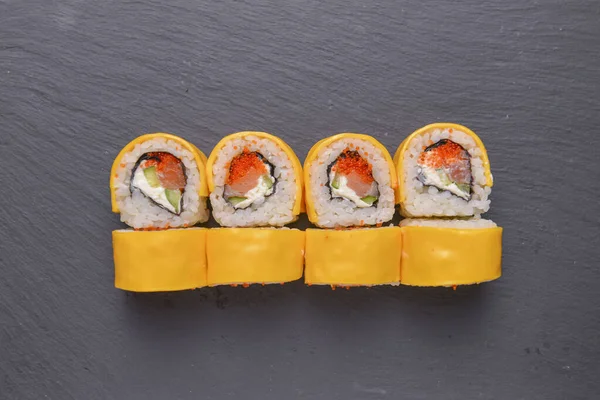 Different Sushi rolls, sushi set rolled in cheese. California philadelphia sushi rools served on a black chalk board. Japanese cuisine concept.