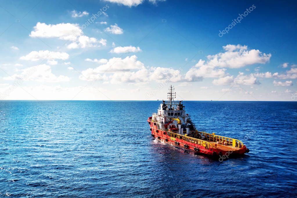Supply boat or crew boat transfer cargo to oil and gas industry and moving cargo from the boat to the platform, boat waiting transfer cargo and passenger between oil and gas platform for hard work in offshore.