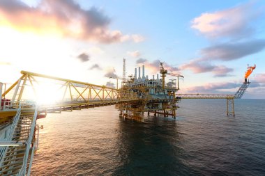 Offshore oil  platform in sunset or sunrise time. Construction of production process in the sea. Power energy of the world. clipart