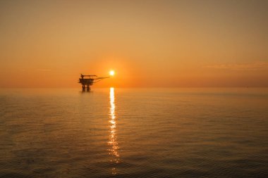 Offshore petrol sondaj platformu platformu gündoğumu veya günbatımı zamanında. Üretim sürecinde deniz inşaatı. Dünyanın gücü enerji.