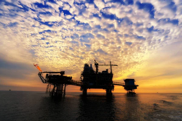 シルエット 日没や日の出の時間のオフショア石油プラットフォーム 海での生産プロセスの構築 世界の電力エネルギー — ストック写真