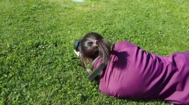 Kadın fotoğrafçı çimenlerin üzerinde DSLR fotoğraf makinesi kullanma