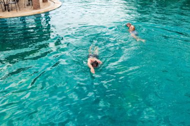 İki beyaz erkek açık gezinme bir yüzme havuzunda yüzme üstten görünüm