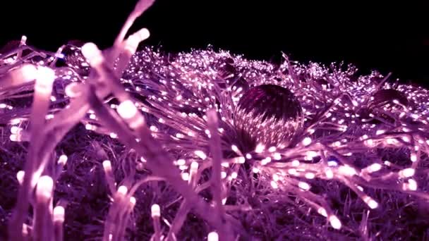 圣诞树上有紫色的仙女灯和装饰品 照亮新年的树在夜晚闪烁和闪亮的装饰品 — 图库视频影像
