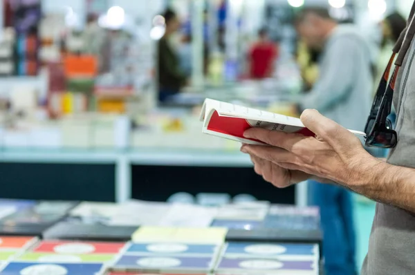 Bir kitap kitap standında Fuar tutan adam el