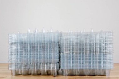 Bir tabloda bir yığın boş plastik yumurta paketleri yan görünüm.