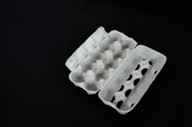 Boş karton yumurta kutusu siyah keçe zemin üzerine.