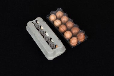 Arka plan üzerine siyah izole yirmi tavuk yumurta karton ve Plastik kutular, hissettim.