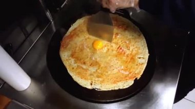 Peynir, Türk Sauge (sucuk) ve yumurta, hızlı hareket çekimi ile bir krep hazırlamak Cook.