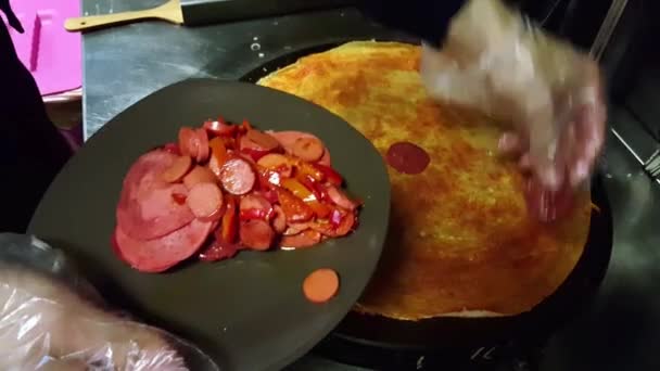 Cozinhe colocando um pouco de molho turco (sucuk) no crepe em um fogão preto — Vídeo de Stock