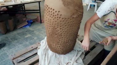 12. Uluslararası Eskişehir Terra Cotta Sempozyumu 'nda heykel üzerinde çalışan sanatçı kadın