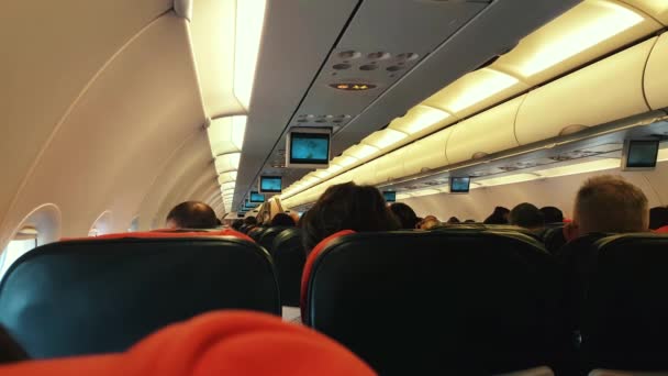 비행 중 좌석에 승객이 있는 비행기의 객실 — 비디오