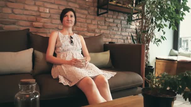 Lonely kaukasiska kvinna i klänning väntar hennes datum i ett kafé — Stockvideo
