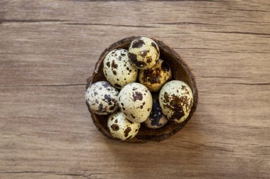 Kahverengi ahşap arka planda bıldırcın yumurtaları. Düz yatıyordu, üst görünüm. Paska