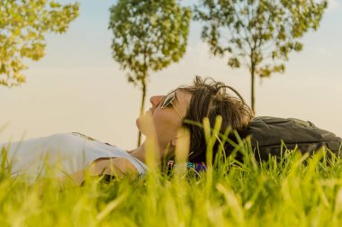 Esmer kadının sırtında natu yeşil çim üzerinde yalan