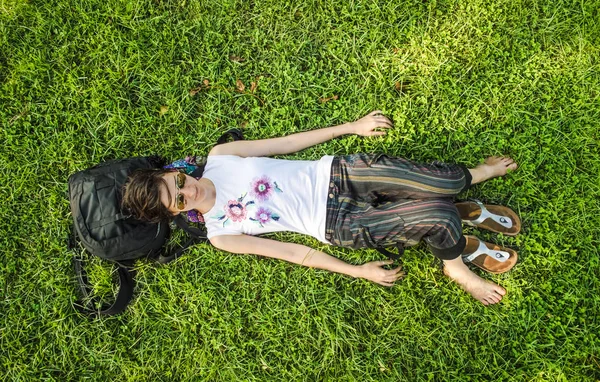 Brunetka kobieta korzystających, leżącego na plecach na zielonej trawie w natu — Zdjęcie stockowe