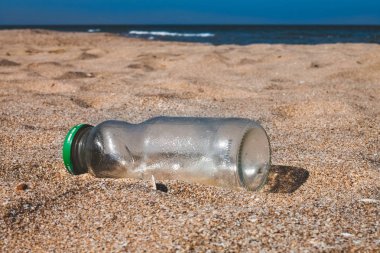 Boş cam şişe çöp sahilde terk etti.