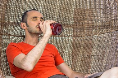 Yetişkin adam içme alkollü Drink itibaren bir kırmızı büyük Bottle