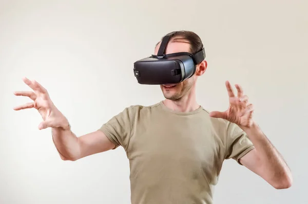 Homem explorando a realidade virtual de tecnologia moderna com exibição montada na cabeça no fundo branco — Fotografia de Stock