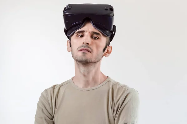 Retrato de um homem morena bonito com óculos de realidade virtual na cabeça no fundo branco — Fotografia de Stock